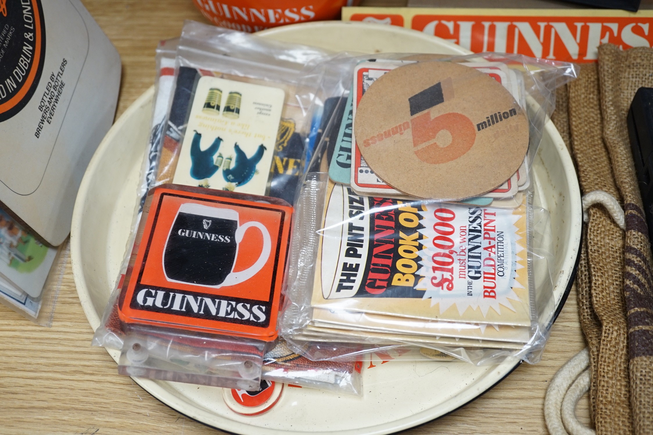 A large quantity Guinness advertising material, including a table lamp with Guinness shade, signage, bar mats, camera etc